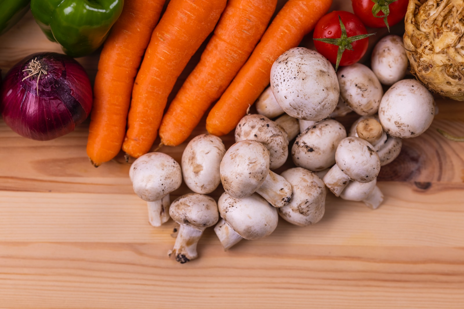 carrots and white garlic on white wooden table